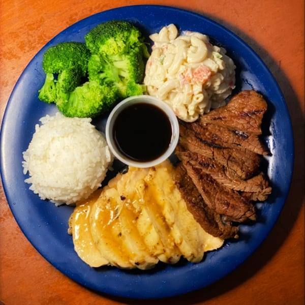 A Papa Nalu Aloha Grill plate with grilled steak, chicken, rice, macaroni salad, broccoli, and dipping sauce.